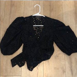 Black wrap top with tags with eyelet detail.